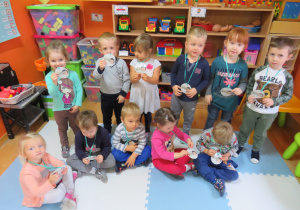 Dzieci z grupy Motylki pokazują emblematy z okazji Dnia Jeża.